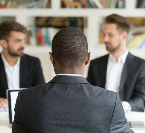 Two people interviewing black candidate