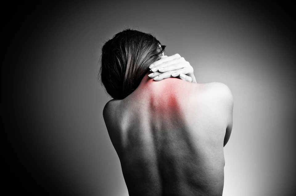 Photo of woman holding neck in pain