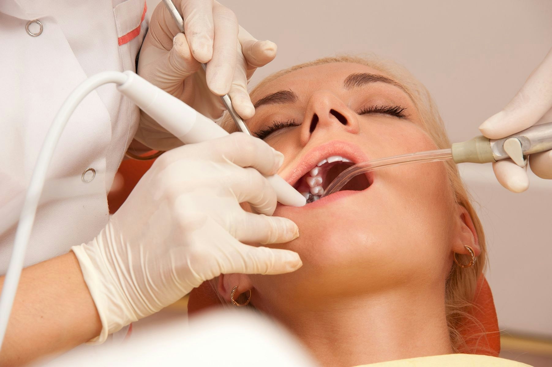 Woman undergoing dental procedure with eyes closed