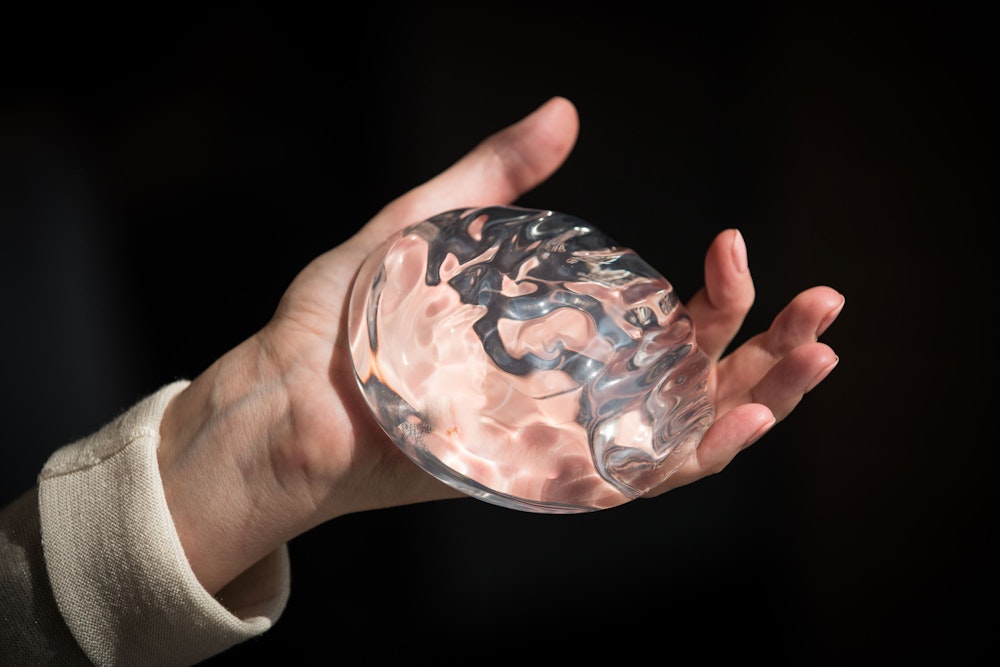 Person holding breast implant in hand
