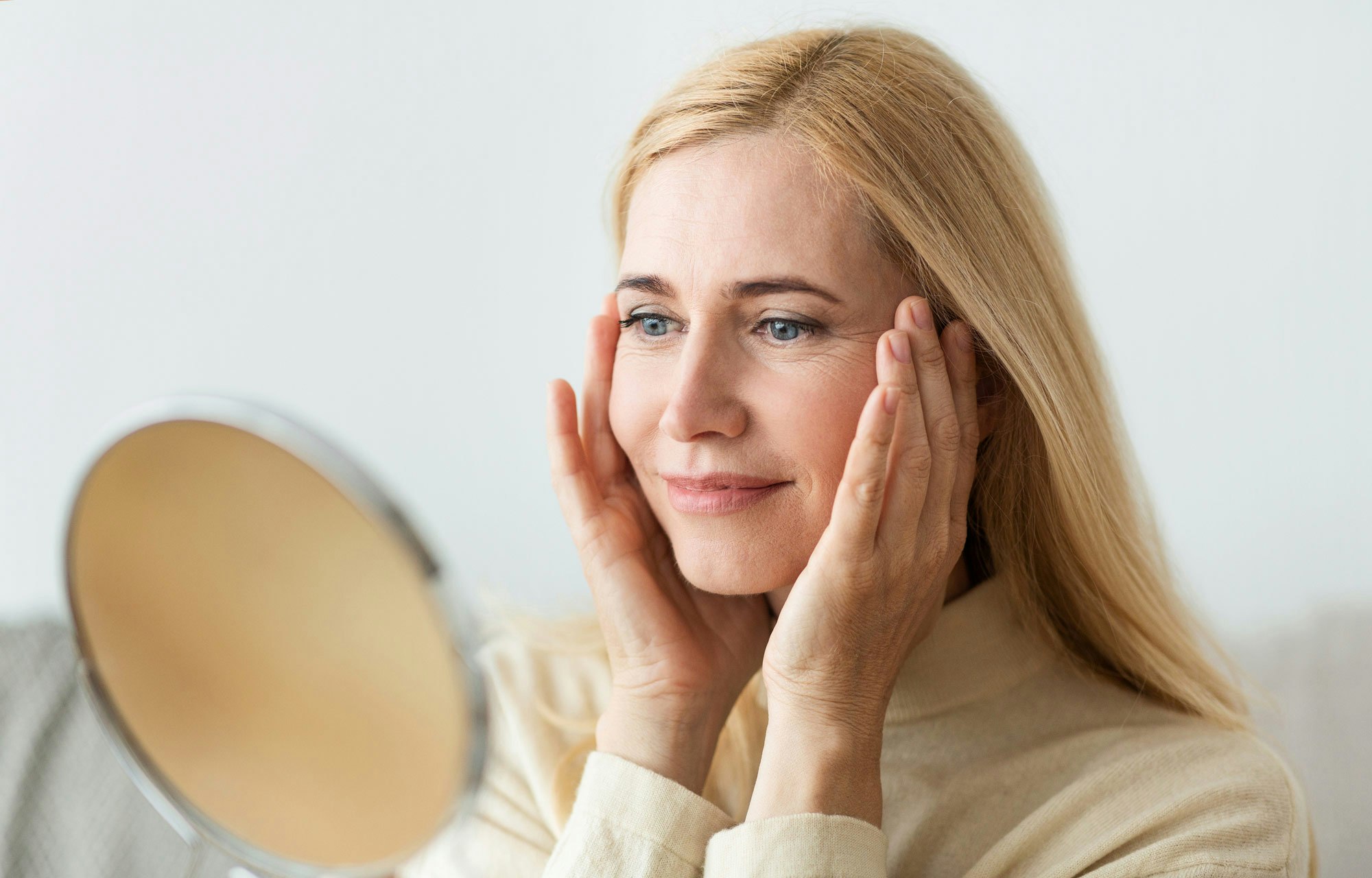 Woman checking face in the mirror