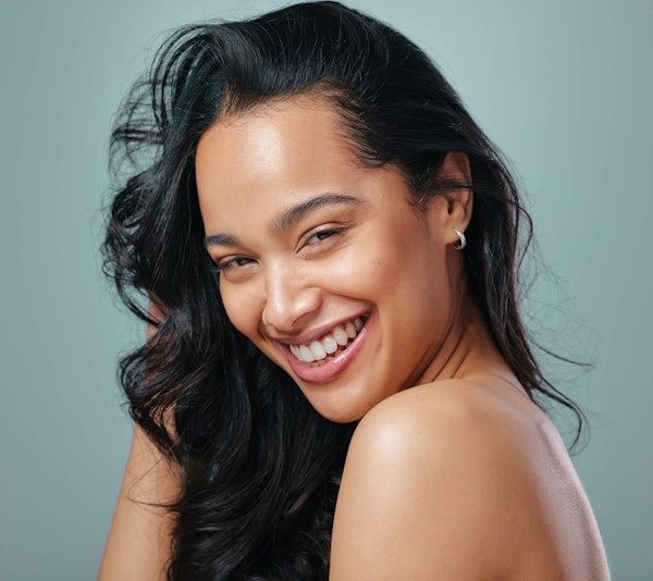 Smiling woman touching face