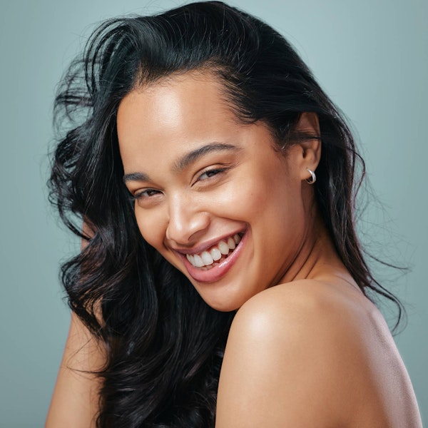 Smiling woman touching face