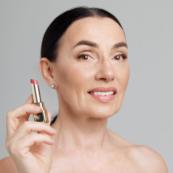 Woman holding lipstick after combining treatments