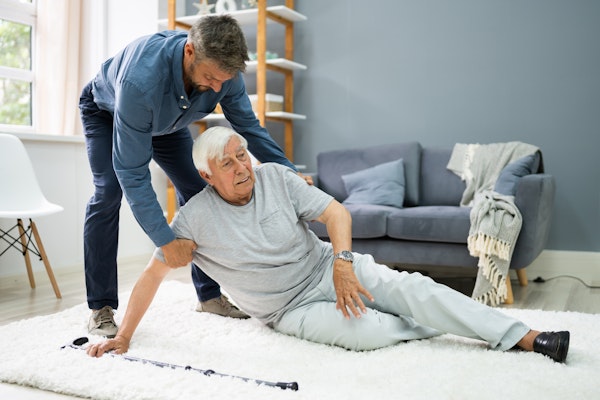 Son helping older father who fell down