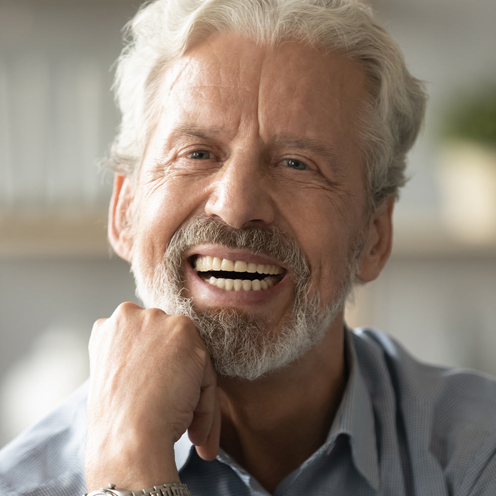 Smiling older man with chin resting on hand
