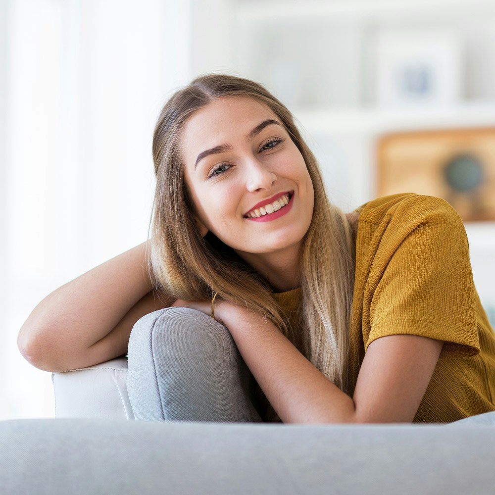 Younger woman smiling on couch