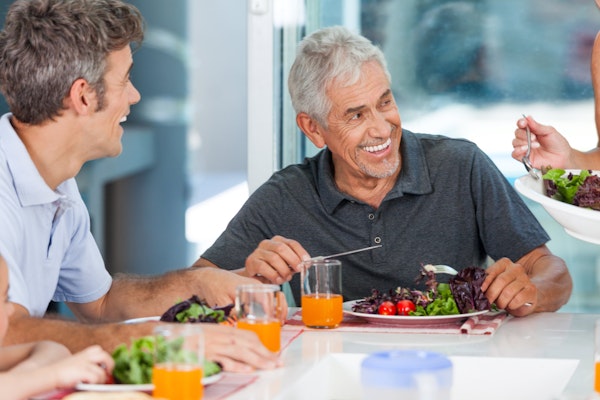 Smiling mature man while eating food