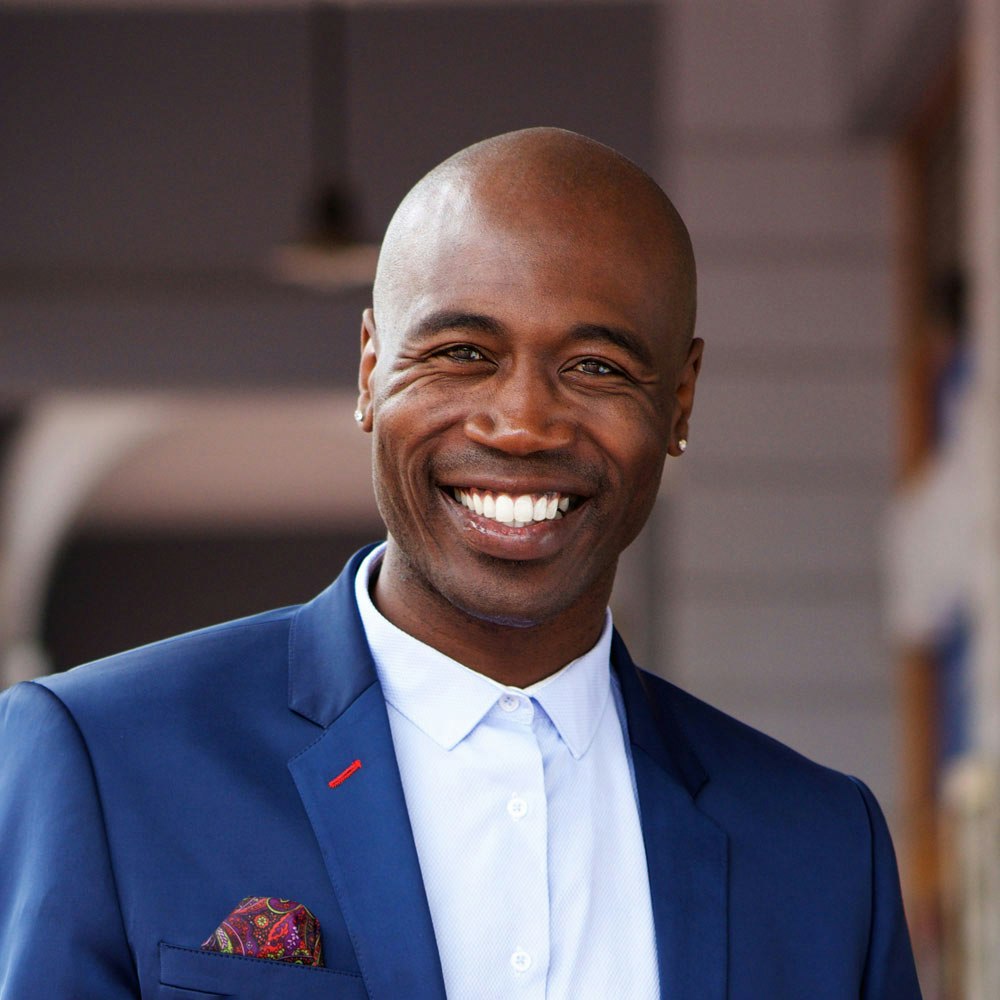Smiling man with dental crowns in blue suit