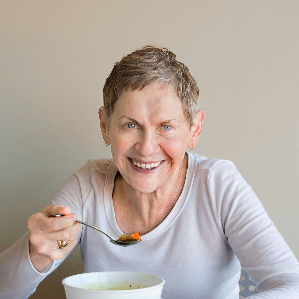 Woman enjoying a bowl of soup after dental bonding procedure