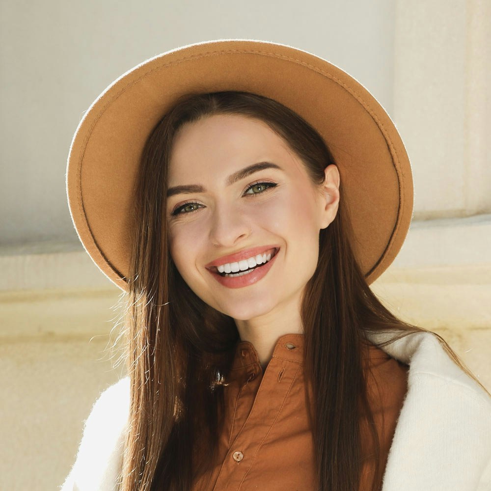 Smiling woman with teeth whitening and sun hat