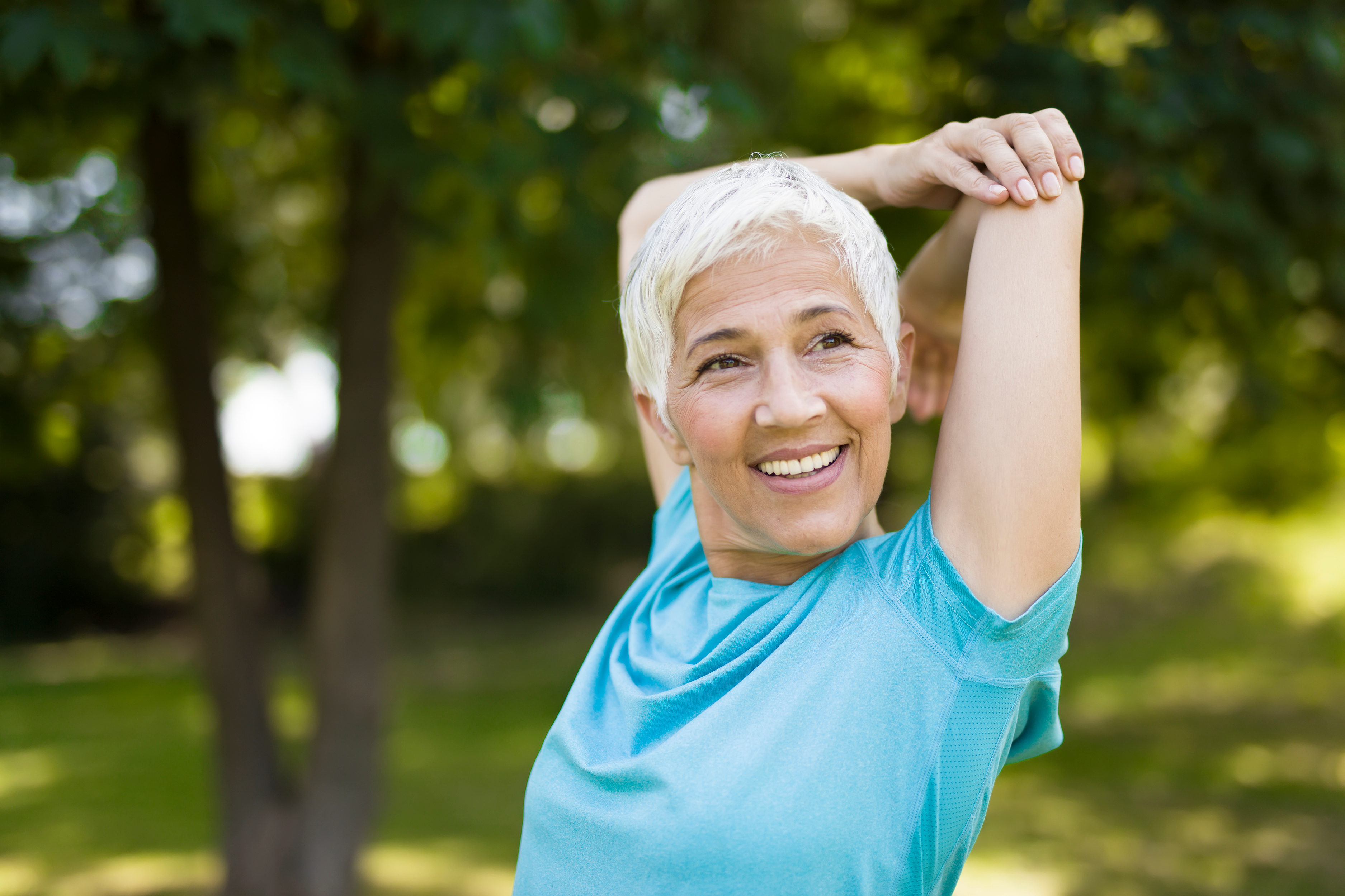 Mature woman after Explore Full Mouth Reconstruction smiling and stretching