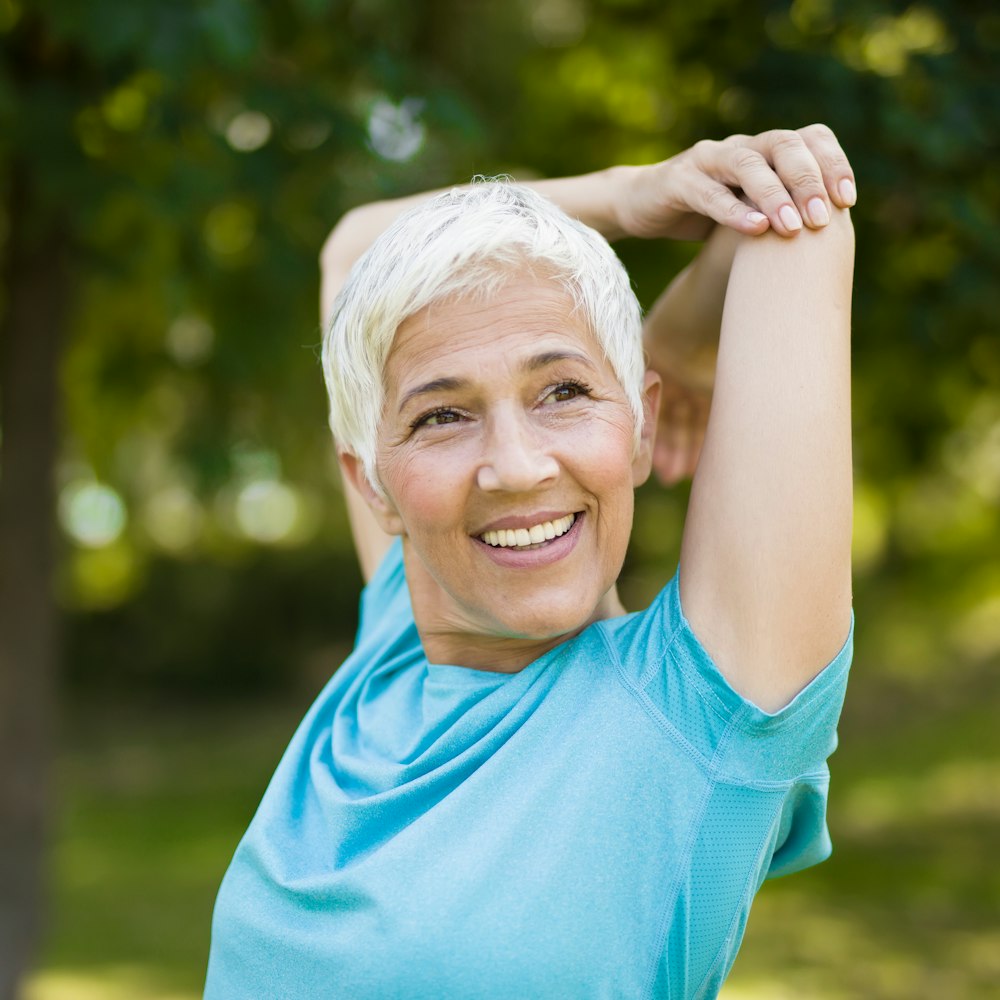 Mature woman after Explore Full Mouth Reconstruction smiling and stretching