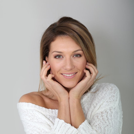 Smiling woman resting her head in her hands