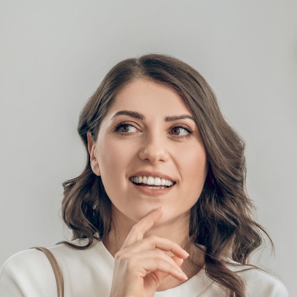 Smiling woman touching chin
