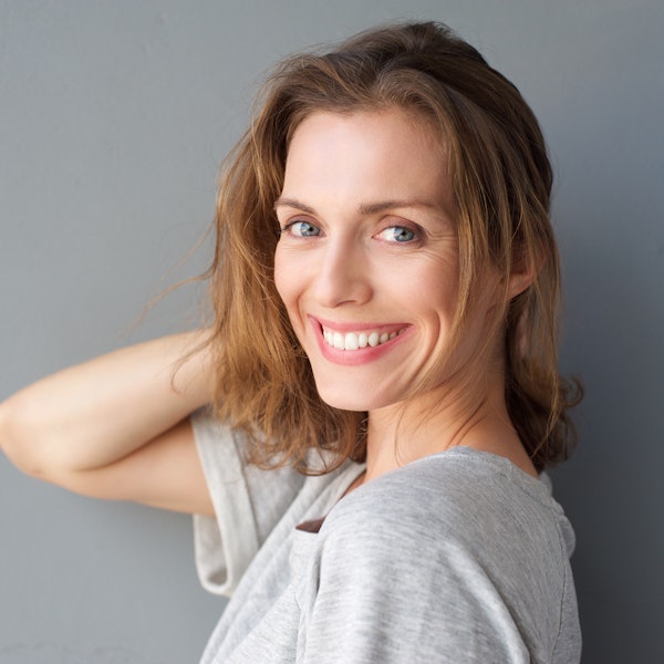 Smiling woman pulling hair back after TMJ treatment