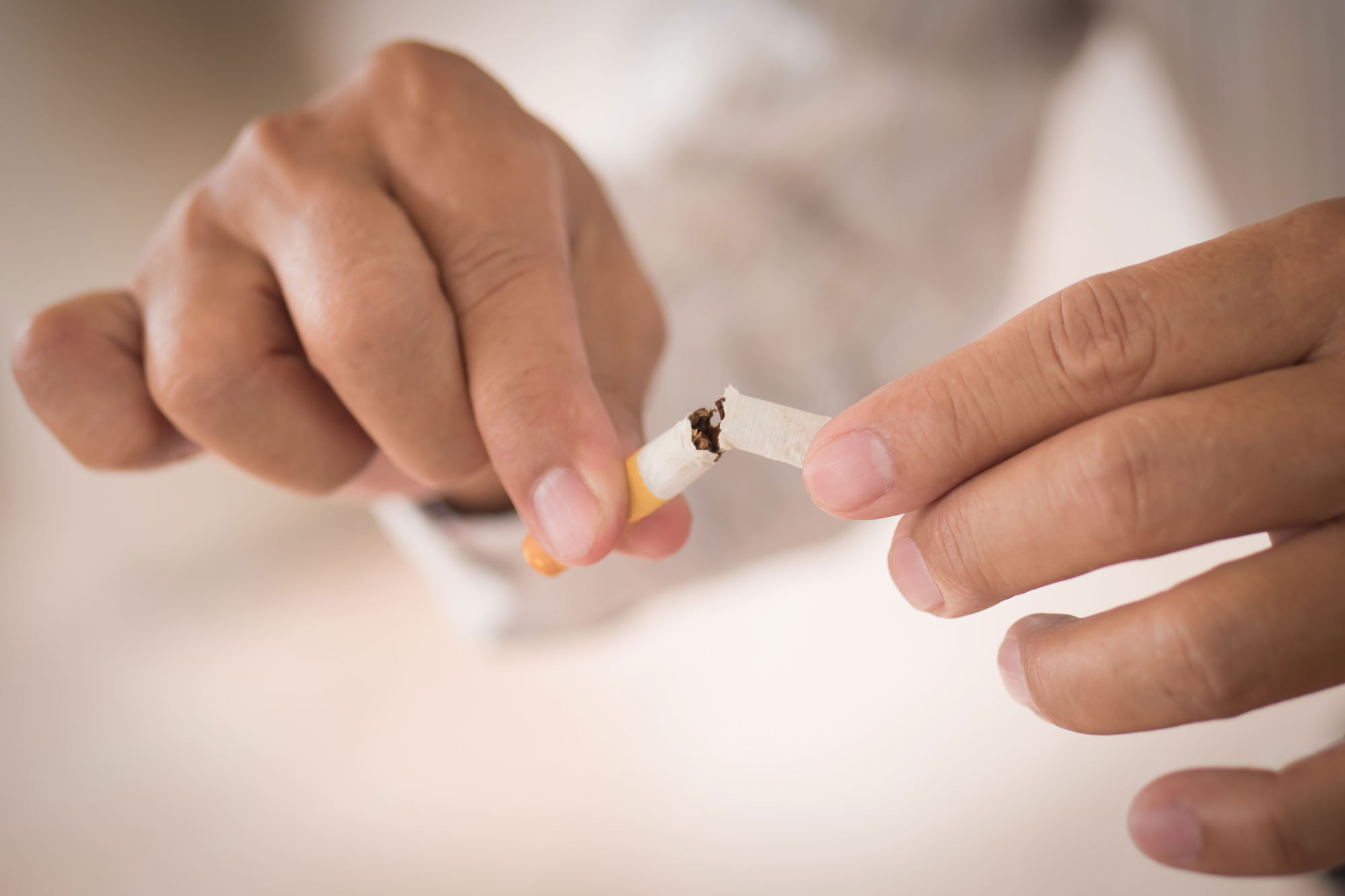 Man breaking cigarette