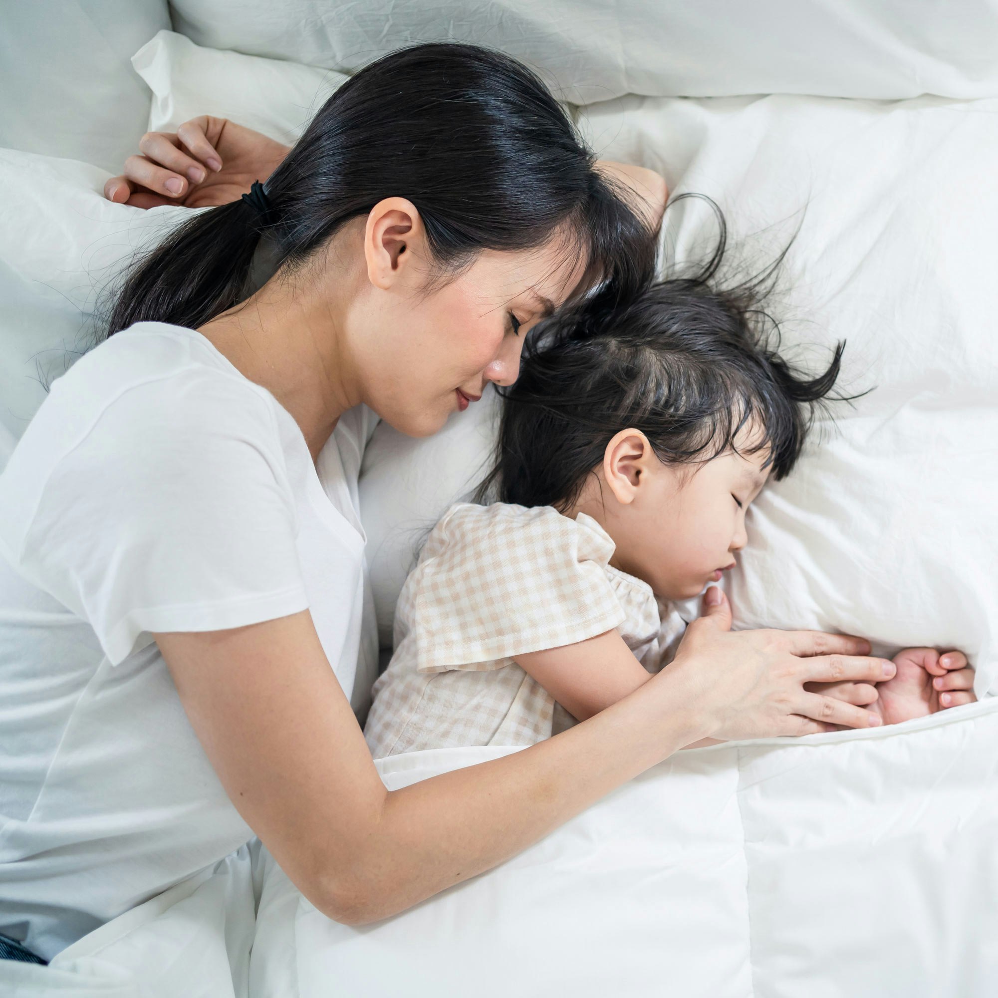 Mom and baby sleeping in bed