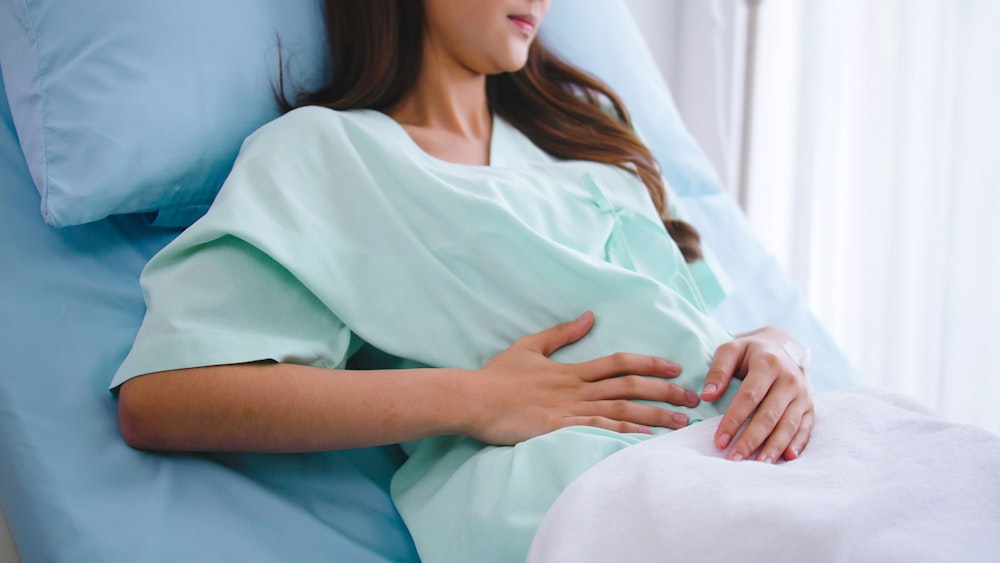 patient holding hand to abdomen