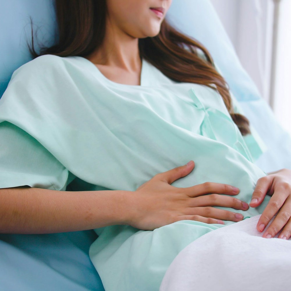 patient holding hand to abdomen