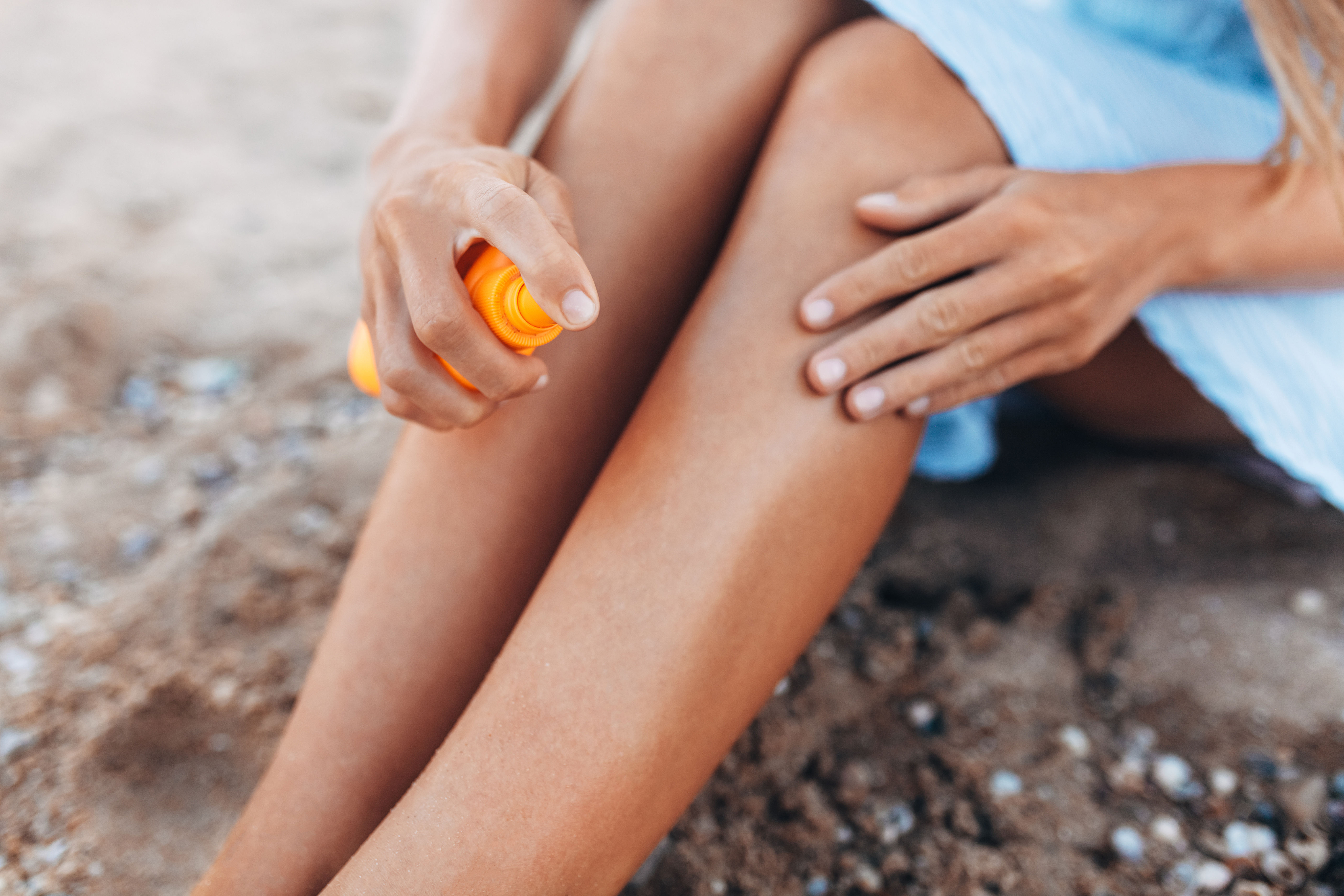 Woman applying sun screen to her legs