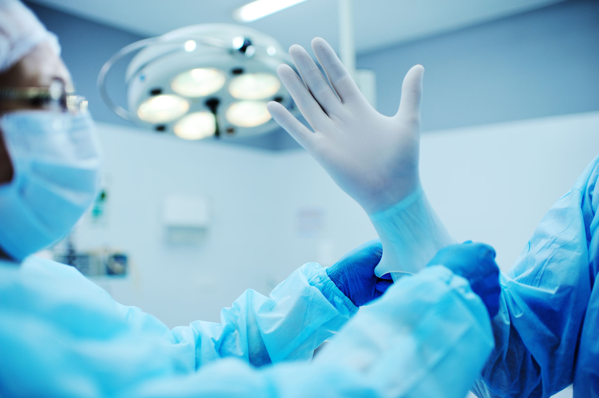 glove being placed on a surgeon’s hand