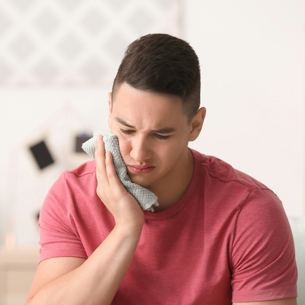 Young man with cold compress
