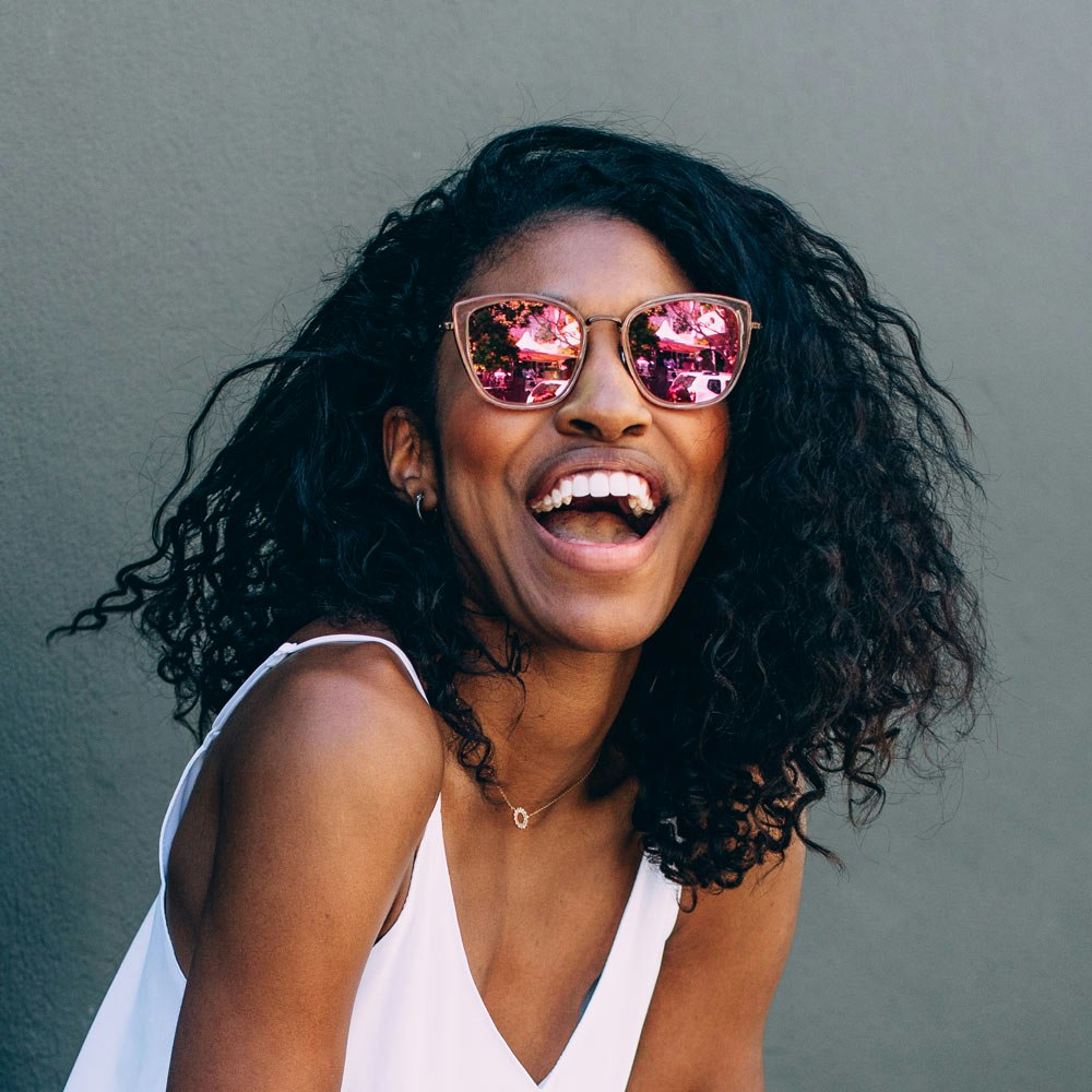 Woman wearing sunglasses and teeth whitening