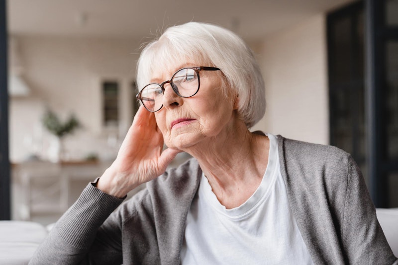Elderly woman considering dental implants and looking worried