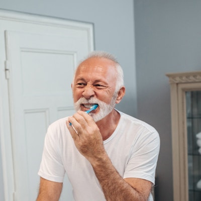 Older man brushing teeth