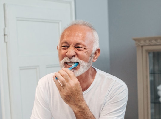 Older man brushing teeth