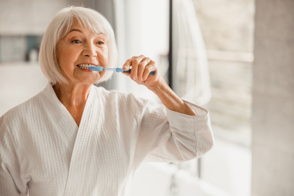 Mature woman brushing her teeth