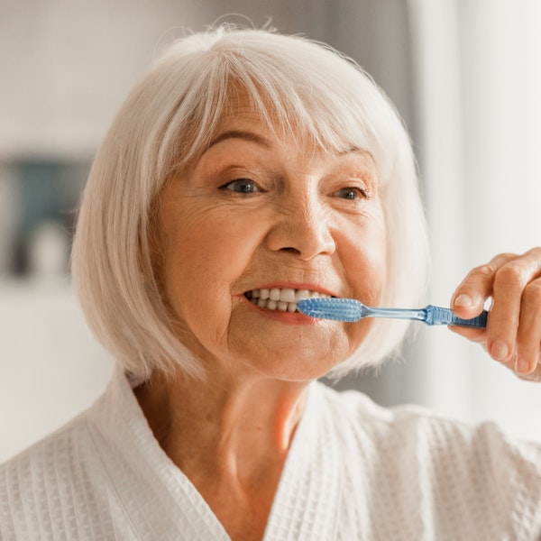 Mature woman brushing her teeth
