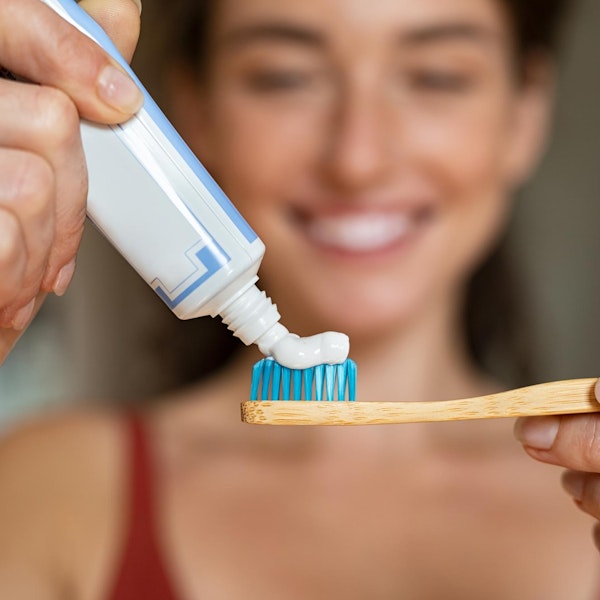 Woman putting toothpaste onto toothbrush
