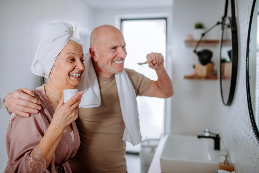 Smiling couple brushing teeth
