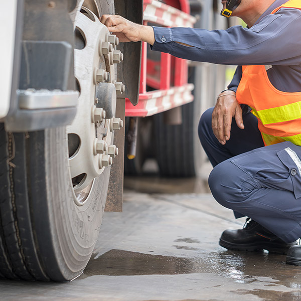 Inspector looking at truck wheels