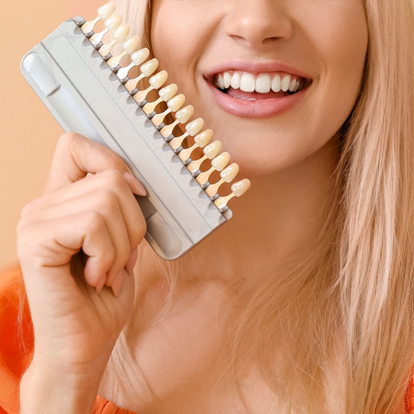 woman holding veneers shades