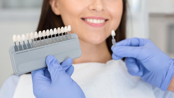 Woman comparing different veneer shades at the dentist's office