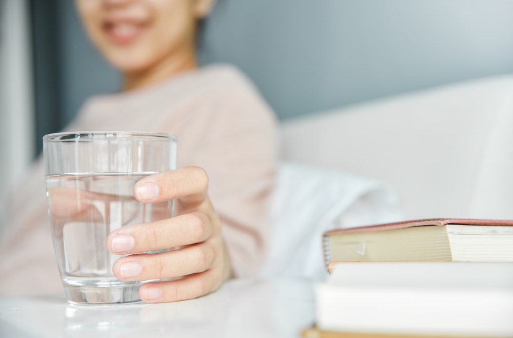 Close up of woman grabbing glass of water