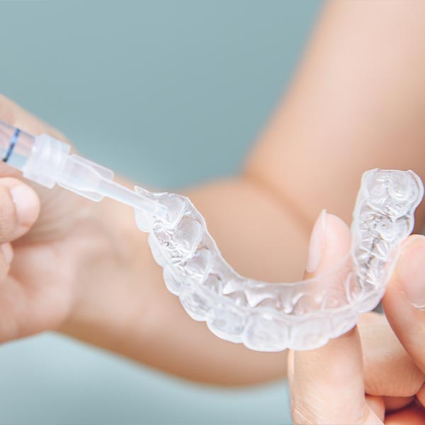 gel being applied to teeth whitening tray