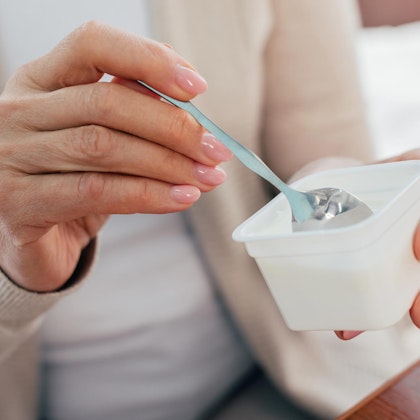 Woman scooping out yogurt